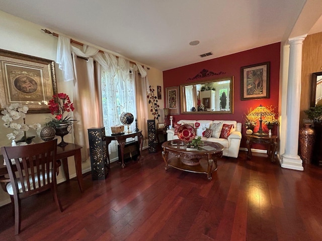 living room with decorative columns and dark hardwood / wood-style floors