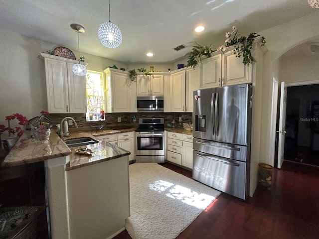 kitchen featuring dark hardwood / wood-style flooring, stainless steel appliances, sink, kitchen peninsula, and stone counters