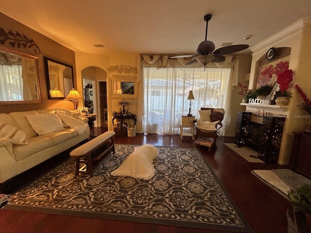 living room featuring ornamental molding, a fireplace, hardwood / wood-style floors, and ceiling fan