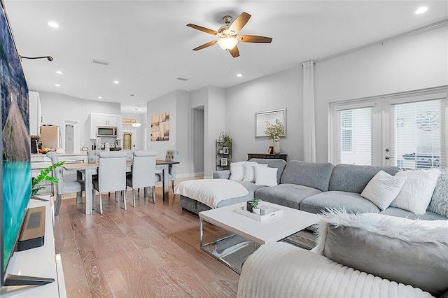 living room with ceiling fan and light hardwood / wood-style floors