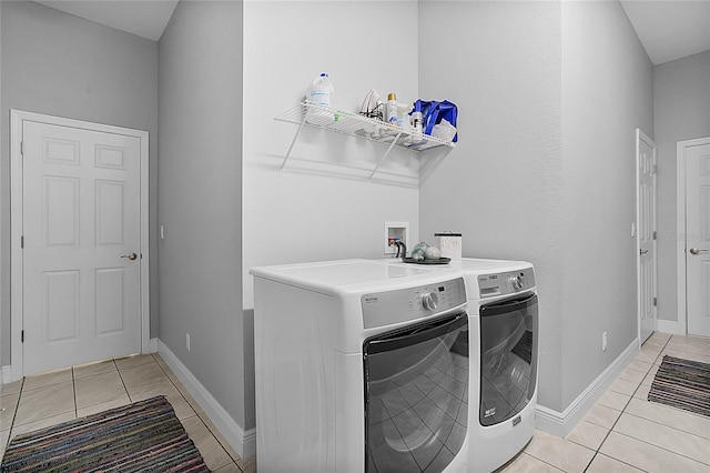 washroom featuring washer and clothes dryer and light tile patterned floors