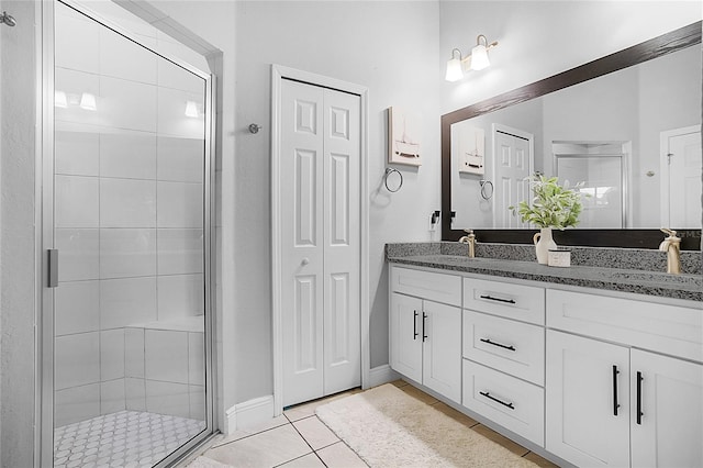 bathroom featuring tile patterned flooring, vanity, and walk in shower