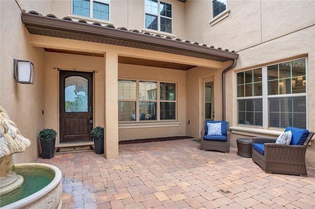 doorway to property featuring a patio area and stucco siding