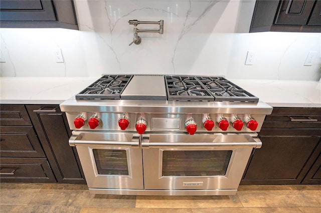 kitchen with tasteful backsplash, range with two ovens, and dark brown cabinets