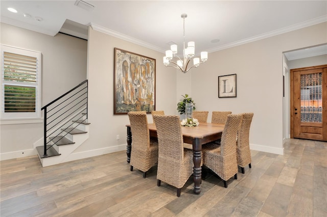 dining area featuring light wood finished floors, visible vents, and ornamental molding