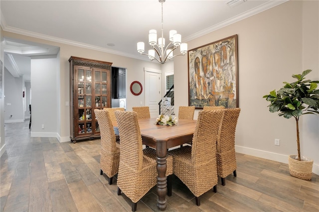 dining space featuring light wood finished floors, a notable chandelier, baseboards, and crown molding