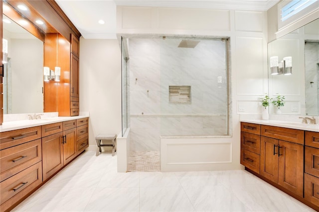 full bathroom featuring two vanities, ornamental molding, a walk in shower, and a sink