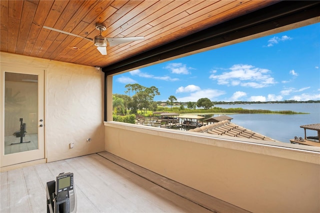 balcony with a water view and a ceiling fan