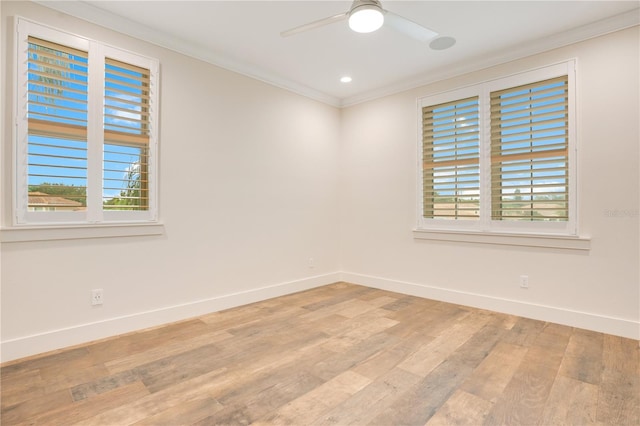 spare room featuring a ceiling fan, light wood-style flooring, ornamental molding, and baseboards