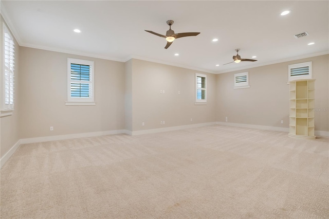 empty room featuring recessed lighting, light colored carpet, crown molding, and baseboards