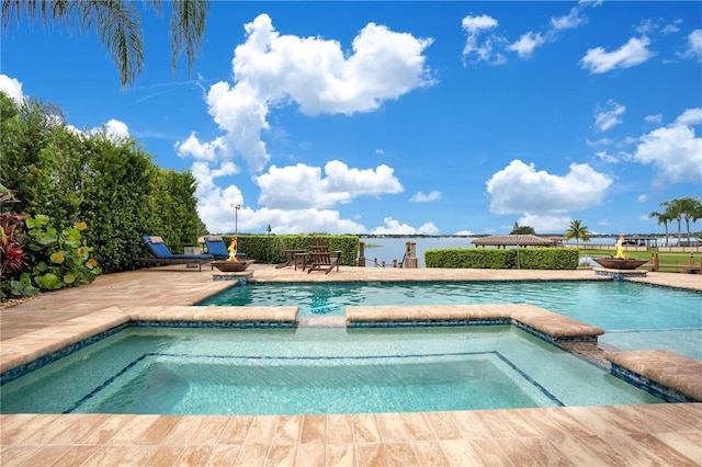 outdoor pool with an in ground hot tub, an outdoor fire pit, and a patio area