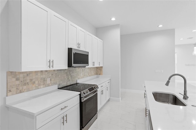 197 Valencia Ridge Dr, Auburndale, FL 33823 - kitchen with appliances with stainless steel finishes, a sink, light marble finish floors, white cabinets, and recessed lighting