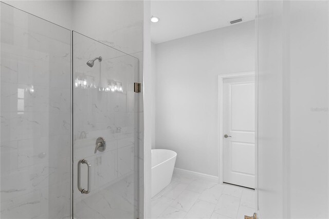 197 Valencia Ridge Dr, Auburndale, FL 33823 - full bath featuring a marble finish shower, marble look tiles, a freestanding bath, and baseboards