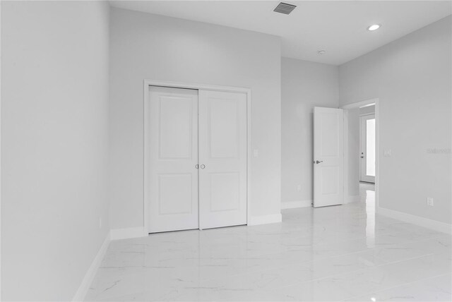 197 Valencia Ridge Dr, Auburndale, FL 33823 - unfurnished bedroom featuring light marble finish flooring, baseboards, a closet, and recessed lighting