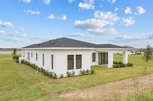 197 Valencia Ridge Dr, Auburndale, FL 33823 - rear view of house featuring stucco siding, a lawn, and roof with shingles