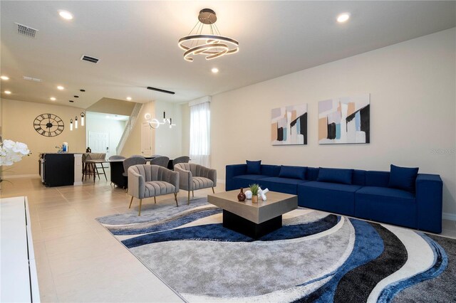 tiled living room featuring a notable chandelier