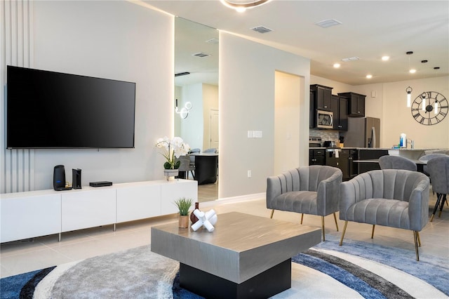 living area with light tile patterned floors, visible vents, and recessed lighting