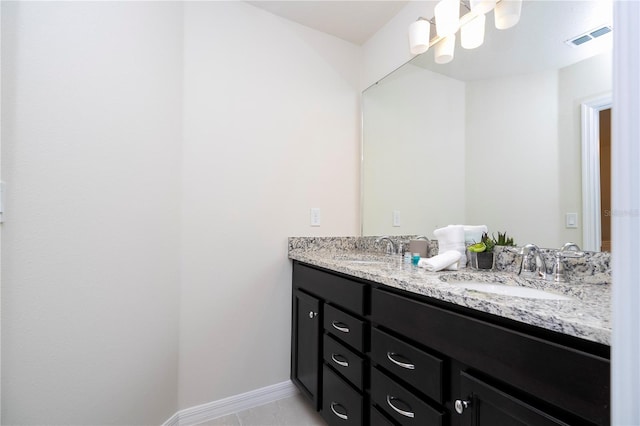 bathroom with double vanity, visible vents, baseboards, and a sink