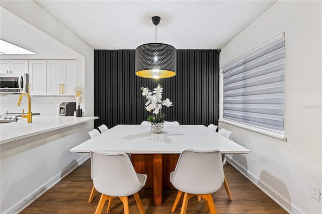 dining area featuring dark hardwood / wood-style flooring and a textured ceiling