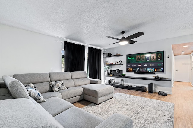 living room with ceiling fan, hardwood / wood-style flooring, and a textured ceiling