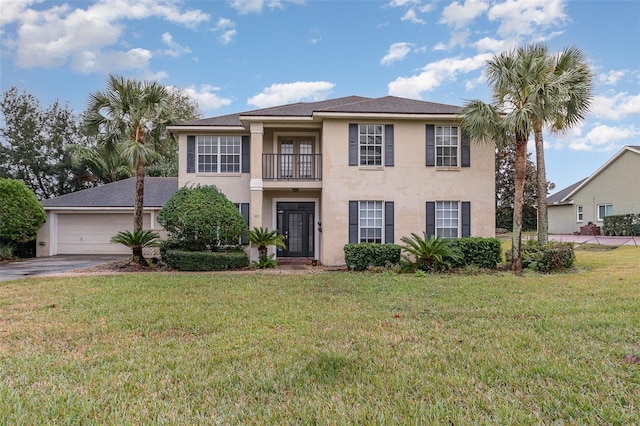 view of front of property featuring a garage, a balcony, and a front yard