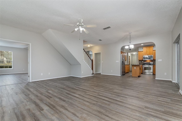 unfurnished living room with wood-type flooring and a textured ceiling