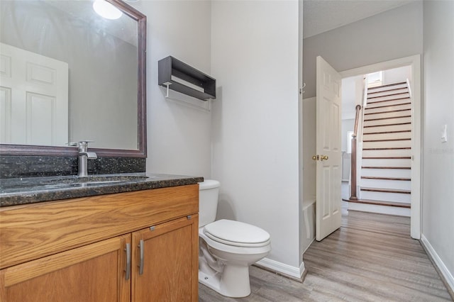 bathroom with vanity, hardwood / wood-style floors, a textured ceiling, and toilet