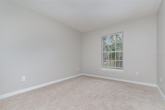 carpeted empty room with a textured ceiling