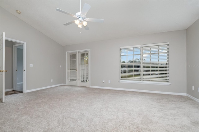 spare room featuring ceiling fan, vaulted ceiling, and light carpet