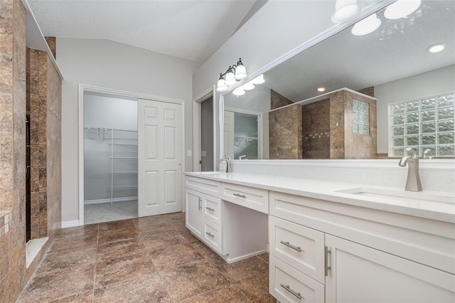 bathroom with vanity, a tile shower, and a textured ceiling