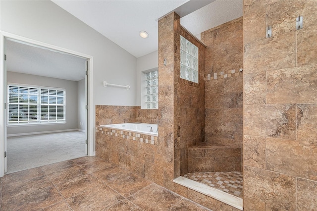 bathroom with a healthy amount of sunlight, independent shower and bath, and vaulted ceiling