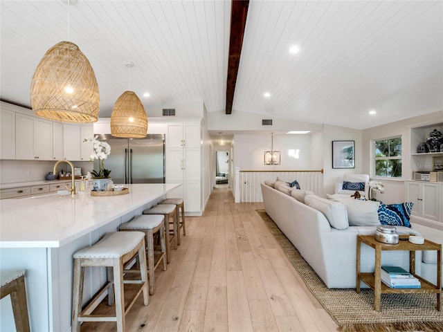 living room featuring lofted ceiling with beams, wooden ceiling, and light wood-type flooring