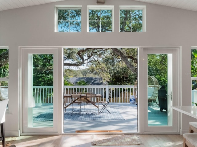 doorway to outside featuring vaulted ceiling