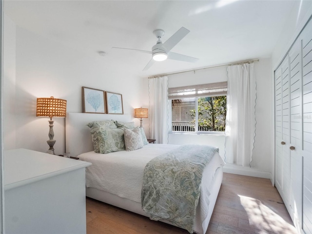 bedroom featuring light hardwood / wood-style flooring, ceiling fan, and a closet