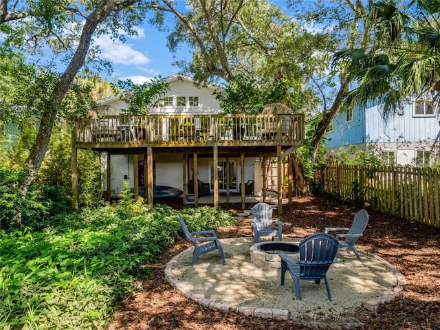 back of house with a wooden deck, a patio area, and an outdoor fire pit