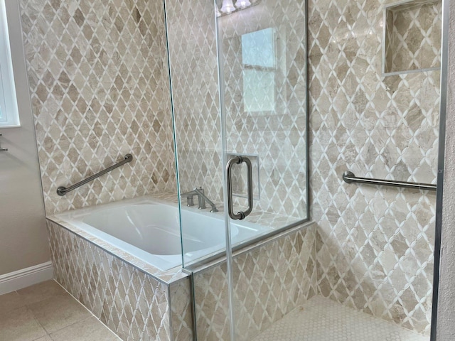 bathroom featuring tile patterned flooring, a garden tub, and a tile shower