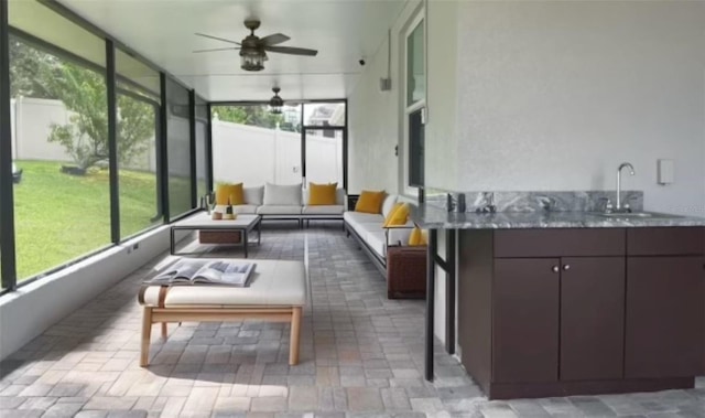 sunroom / solarium with ceiling fan and a sink