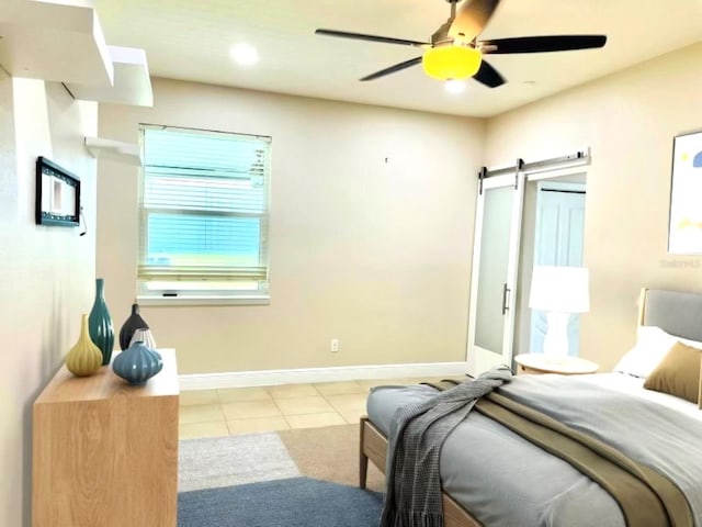 tiled bedroom with recessed lighting, ceiling fan, baseboards, and a barn door