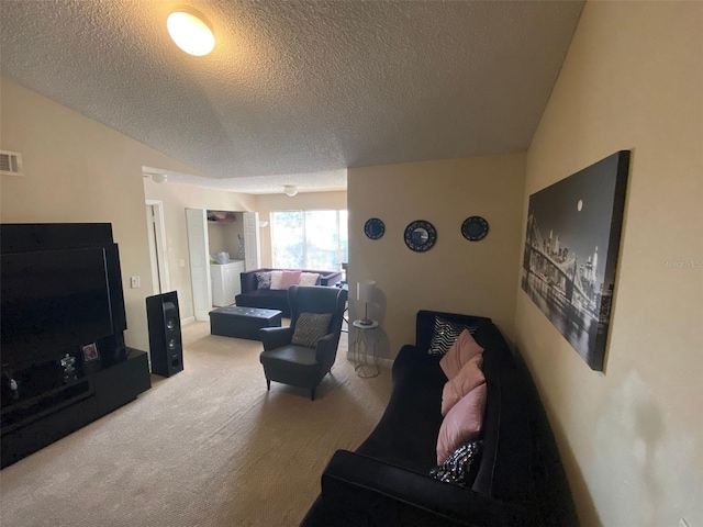 living room with vaulted ceiling, a textured ceiling, washer and dryer, and carpet flooring