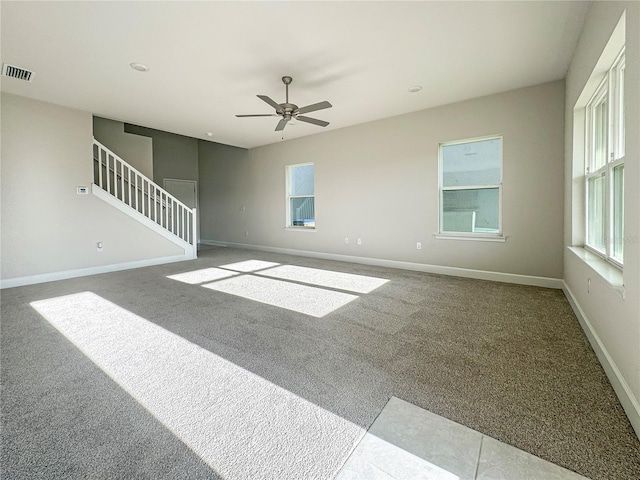 carpeted spare room with ceiling fan and plenty of natural light