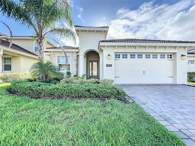 mediterranean / spanish-style home with a garage and a front yard