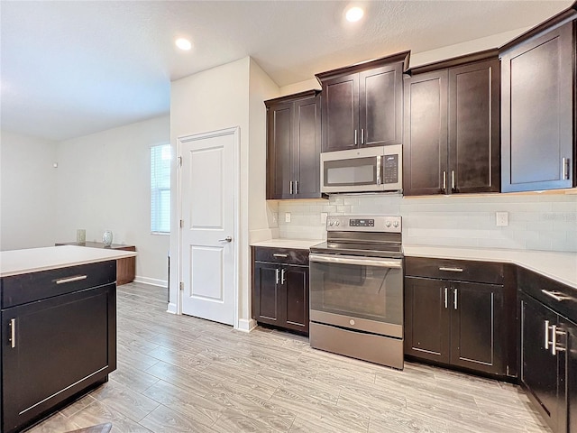 kitchen featuring light hardwood / wood-style flooring, backsplash, appliances with stainless steel finishes, and dark brown cabinets