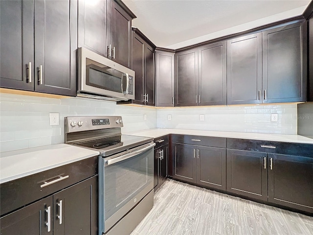 kitchen featuring light hardwood / wood-style flooring, dark brown cabinetry, appliances with stainless steel finishes, and tasteful backsplash