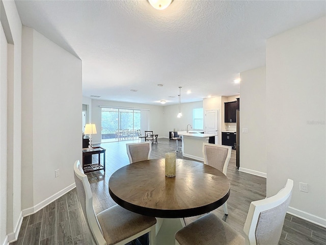 dining area featuring a textured ceiling and dark wood-type flooring