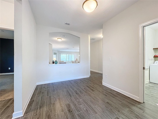 unfurnished room featuring dark hardwood / wood-style floors and washer / clothes dryer