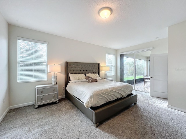 bedroom featuring a textured ceiling, carpet, and access to outside