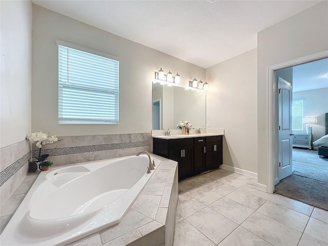 bathroom with a relaxing tiled tub and vanity