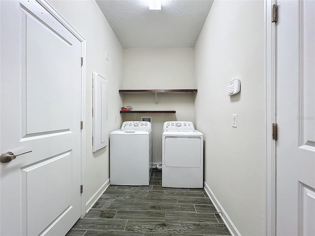 washroom featuring dark hardwood / wood-style flooring, washer and clothes dryer, and a textured ceiling