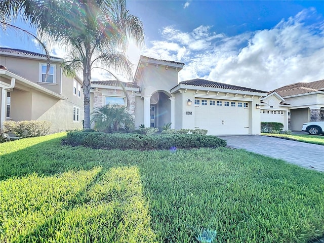 mediterranean / spanish-style house featuring a garage and a front lawn