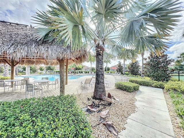 view of community featuring a swimming pool and a patio